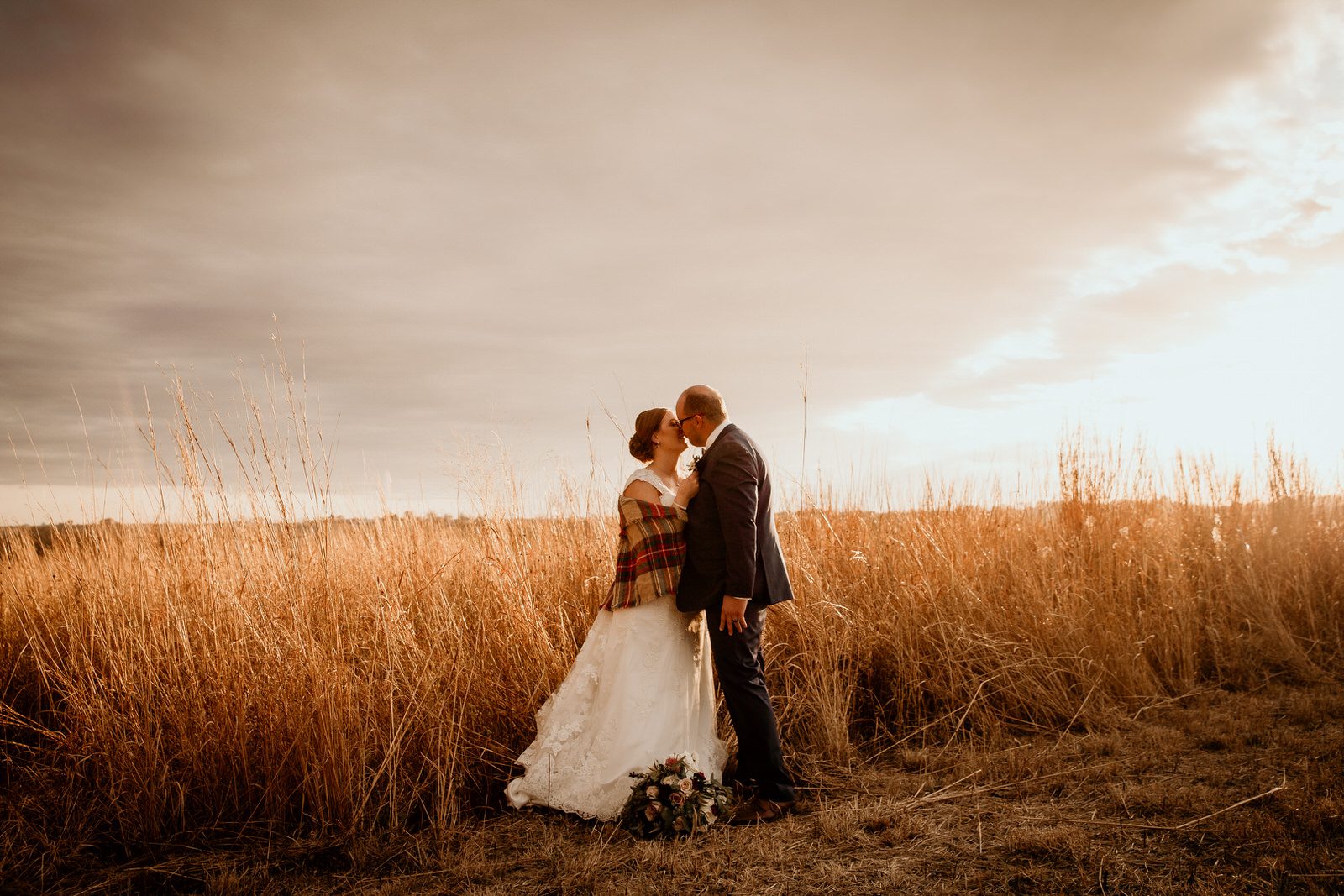 Wedding couple in a field at sunset. Fall wedding. Iowa