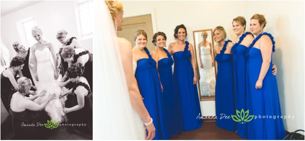 Wedding photo of bride getting ready with bridesmaids all around and in mirror