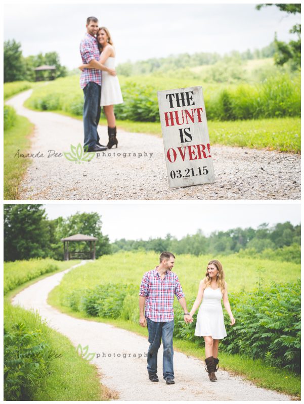 Outdoor engagement photo the hunt is over sign walking a path holding hands