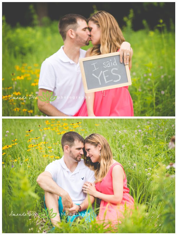 Outdoor Engagement photo candid in the grass and flowers i said yes sign kissing