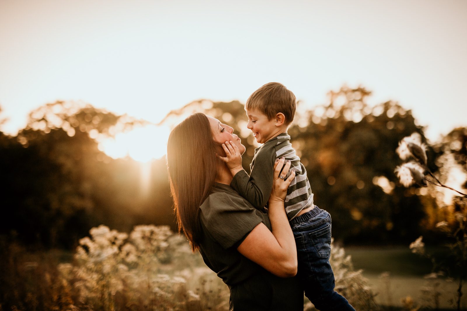 mother and son in a field in iowa at golden hour sunset